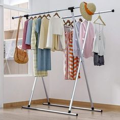 clothes are hanging on the rack in an empty room