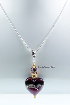 a heart shaped glass pendant on a silver chain