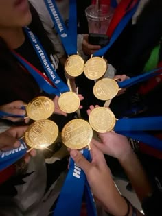 several people holding gold medals in their hands