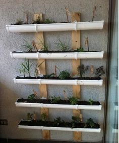 a wall mounted shelf filled with plants on top of a tiled floor next to a window