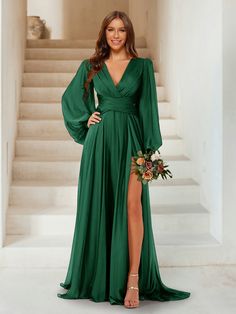 a woman in a green dress posing for the camera with her legs slited up