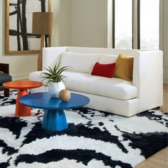 a living room with white couches and colorful tables