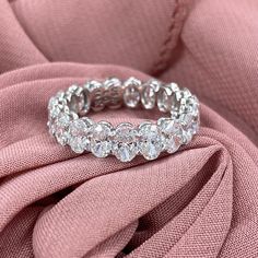 a diamond ring sitting on top of a pink cloth