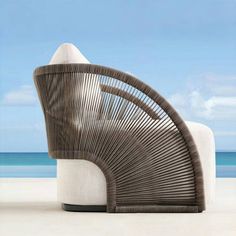 a wicker chair sitting on top of a white sandy beach next to the ocean