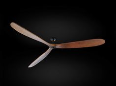 a ceiling fan with wooden blades on a black background