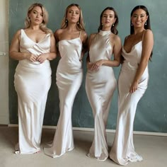 three women in white dresses standing next to each other with their hands on their hips