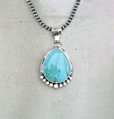 Kingman Sky Blue Turquoise Sterling Silver Necklace on your choice of chain. The setting is a chunky teardrop stone that is 27mm x 22mm and in a Bezel setting. The 925 Sterling Silver has been lightly oxidized.  Your choice of an 18" 3mm Navajo Pearls or 18" Silver Chain with Lobster clasp This cool necklace features a chunky, pear shaped turquoise gemstone with a detailed setting. The soothing hue of the turquoise brings out a southwest style vibe, while the silver accents add a touch of elegan Blue Turquoise Necklace With Large Teardrop Stone, Turquoise Teardrop Pendant Necklace With Natural Stones, Turquoise Drop Bohemian Jewelry, Bohemian Turquoise Drop Jewelry, Unique Blue Teardrop Turquoise Necklace, Turquoise Bohemian Drop Jewelry, Turquoise Teardrop Pendant Necklace With Large Stone, Artisan Blue Turquoise Teardrop Pendant Necklace, Artisan Blue Teardrop Pendant Necklaces