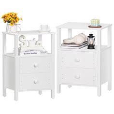 two white nightstands with flowers and books on top, one is open to show the contents