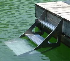 a boat ramp sitting on top of a body of water next to a wooden dock