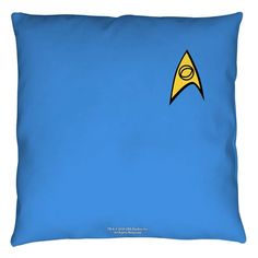 a blue pillow with a yellow and black star trek logo on the front, against a blue background