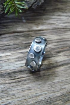 This unisex statement ring is made with 1/4 inch sterling silver in a thick gauge making the piece very sturdy. The band is adorned with sterling elements that vary in size The entire piece was oxidized and polished offering an industrial appearance. This piece is perfect for a man or a woman. Upon purchase send me a message with the ring size. Made to order. To make my pieces withstand loving wear and the test of time, each bracelet is made with very thick gauges of sterling silver. Great thoug Unique Stamped Ring Jewelry, Unique Everyday Sterling Silver Rings, Unique Stamped Silver Rings, Brutalist Sterling Silver Rings With Oxidized Finish, Brutalist Sterling Silver Ring For Anniversary, Sterling Silver Rings With Oxidized Finish, Unique Sterling Silver Round Band Ring, Brutalist Sterling Silver Rings For Gift, Brutalist Sterling Silver Rings As Gift