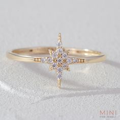 a yellow gold ring with white diamonds on the bottom and an open star design in the middle