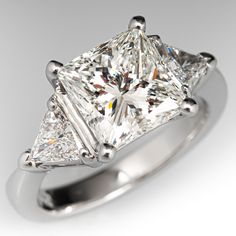 a princess cut diamond ring with three prongs on the sides, set in 18k white gold