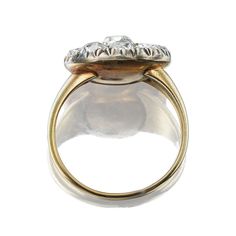 an antique diamond and gold ring, with three stones in the center on a white background