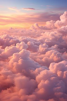 the view from an airplane window shows clouds and bright pink hues in the sky