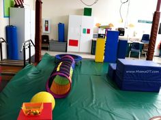 children's play area with various toys on the floor and inflatable structures