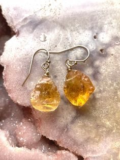 Glowing like the warm sun are these stunning and unique pair of raw citrine dangle earrings.  Organic cuts make these earrings really stand out and when the sun hits them they are sure to shine. Paired  them on 14k gold fill  for a truly unique gift for a earthy chic! Citrine is one of the birthstones for November.  Raw cuts of natural citrine gemstone  Made to order  14k gold fill or sterling silver metal  About 30mm dangle length  Comes in pink velvet jewelry bag for gift giving and storage Mo Orange Citrine Gemstone Earrings, Amber Citrine Drop Earrings, Nickel-free Citrine Dangle Jewelry, Amber Teardrop Earrings With Natural Stones, Orange Citrine Earrings Gift, Amber Citrine Earrings With Ear Wire, Amber Citrine Teardrop Earrings, Amber Citrine Dangle Earrings, Handmade Citrine Dangle Earrings