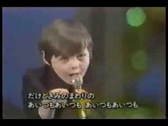 a young boy singing into a microphone with the words in japanese on it and an image of