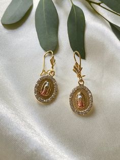 Virgen de Guadalupe 14K Tricolor Gold Plated Earrings, with Diamond all around the earring. Earrings with the Virgen de Guadalupe on each earring. Includes Beautiful wooden gift box. Gold Dangle Earrings With Halo Design, Gold Dangle Jewelry With Halo Design, Wedding Yellow Gold Jewelry With Miraculous Medal, Gold Halo Design Dangle Jewelry, Yellow Gold Miraculous Medal Jewelry For Wedding, Gold Halo Earrings Perfect As A Gift, Gold Halo Earrings For Gift, Gold Halo Earrings Perfect For Gifts, Oval Gold Halo Earrings