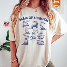 "Seals Of Approval Funny Retro T-Shirt, Vintage 90s Seal T-shirt, Funny 90s Shirt, Vintage Minimalistic Unisex Gag Tee, Silly Shirt Gifts, Seal lovers --------HOW TO ORDER----------- 1)select SHIRT COLOR 2)select your desired Size 3)Double check the size chart to find your fit 4)click \"Add to Cart\" and continue shopping to add another shirt for your loved ones. Browse our selection of more shirts/sweatshirts ------ https://www.etsy.com/shop/KenzAmericanTee?ref=seller-platform-mcnav 👉Reading the SIZE CHART:  Please note that the sizing chart includes the measurements of one side of the shirt, not the circumference.  👉Please review all the sizing charts that were added to the product pictures. Our T-Shirt and crewneck Sweatshirt quality is top-notch and can be used everywhere in daily li Funny Print Crew Neck Top For Everyday, 90s Style Cotton Tops For Everyday, Funny Short Sleeve Top With Front Print, Everyday Retro T-shirt With Funny Print, Funny Cotton Tops For Everyday, Relaxed Fit Tops With Funny Print, Everyday Funny Print Crew Neck Shirt, Everyday Crew Neck Shirt With Funny Print, Funny Graphic Print Tops For Everyday