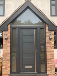 a grey front door on a brick house