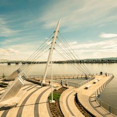 an aerial view of a boat dock with people walking on the walkway and water in the background