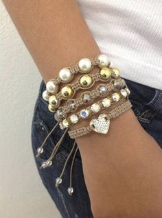 a close up of a person's arm wearing bracelets with pearls and beads