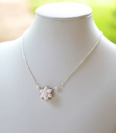 a white necklace with a flower on it