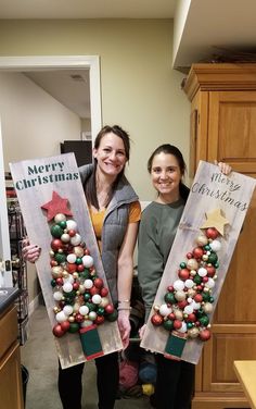 two women holding christmas decorations in their hands