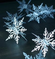 several snowflakes are shown on a table with some light coming from the top