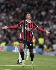 a soccer player with his arms out in the air and looking up to the sky