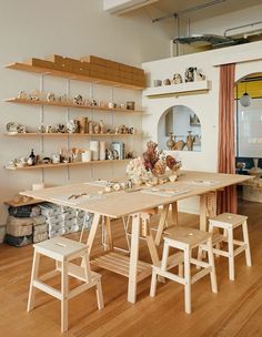 a dining room table with chairs and shelves on the wall