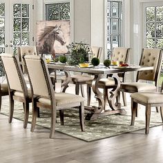 a dining room table with chairs and a rug on the floor in front of it