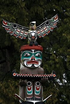 a totema statue with an eagle on it's head and two arms