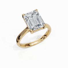 an emerald - cut diamond ring set in yellow gold