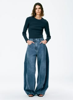 The Classic Wash Denim Sid Jean brings a unique aspect to your denim collection (and may be one of our favs) with its unique fit and design. This jean features both a wide leg silhouette that has a balloon-like shape as it gets tighter when it hits the floor. This pant is a mid-rise with a full bottom. It sits just below the waist and above the high hip. 100% Cotton Denim Jeans Outfit, Handkerchief Top, Satin Corset Top, Godet Skirt, Bleached Denim, All Jeans, Unique Fits, Denim Trends, Denim Collection