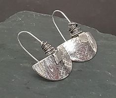 The Half Moon Pattern Earrings have a custom engraved graphic design on argentium silver. There is a 'tag' on each ear wire of fine silver. Organically wrapped argentium silver on fixed argentium silver ear wires. Each pair is handcrafted and specially unique! Silver Etched Round Earrings, Artisan Sterling Silver Etched Earrings, Artisan Etched Sterling Silver Earrings, Silver Etched Earrings As A Gift, Silver Etched Earrings For Gifts, Unique Silver Etched Earrings, Unique Etched Silver Earrings, Silver Etched Metal Earrings, Etched Silver Metal Earrings