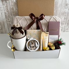 a gift box filled with coffee, chocolates and other holiday treats sits on a table