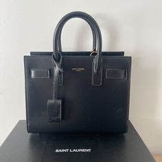 Saint Laurent Handbag Black Never Worn!! Have Dust Bag And Box ! Designer Square Satchel With Branded Hardware, Luxury Square Bag With Branded Hardware, Designer Everyday Luxury Box Bag With Top Handle, Designer Box Bag With Top Handle For Everyday Luxury, Light Luxury Rectangular Box Bag For Formal Events, Modern Square Bags With Branded Hardware, Modern Square Bag With Branded Hardware, Modern Rectangular Bags With Branded Hardware, Light Luxury Everyday Rectangular Bag