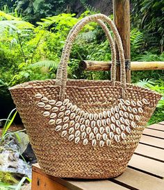 This beautiful handwoven basket bag is made of natural seagrass with cowrie shells stitch on it, the perfect accessory for the summer as a picnic basket bag, bride beach bag with a natural color this bag is easy to mix and match with any outfit. ● Material: Seagrass, cowrie shells ●Quantity listed: 1pc ●Dimension:  Length: 55 cm (top) - 21 inches  Height:  28 cm - 11 inches  Bottom: 20x23 cm - 7x9 inches  ♥ USAGE ● Beach Bag to carry some beach stuff's ● Handbag for just strolling in the city ● Summer bag ●PACKING: We'll be wrapped in white paper, bubble wrap, black stretch film plastic. SHIPPING INFO ● Processing time: 1-2 working days ● Shipping it will take between 2-7 business day by Express DHL or FedEx depending on your location   Asia Pacific: 2-4 days   Australia and New Zealand 3- Handmade Beach Bag For Travel During Beach Season, Tropical Style Shopping Bags For Summer, Bohemian Summer Beach Bag In Bucket Shape, Bohemian Beach Bags In Bucket Shape, Bohemian Bucket-shaped Beach Bags, Bohemian Beach Bags For Shopping, Bohemian Handwoven Bags For Vacation, Natural Bucket-shaped Beach Bag, Bohemian Style Bags For Beach Season Shopping