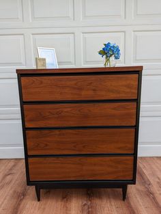 a wooden dresser sitting on top of a hard wood floor next to a white garage door