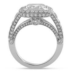 a white gold ring with two rows of diamonds on the band and an oval shaped center stone