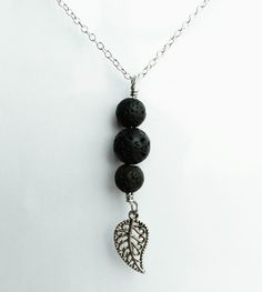 Volcanic Lava Bead Charm necklace made with one 10mm round lava bead in the middle and two 8mm round lava beads on each end. A zinc alloy (lead free) leaf charm dangles from the end. Want a different charm dangling from the end? Check out all of the other charms we have for a personalized look! https://www.etsy.com/shop/PersonalBlessings?section_id=18028058&ref=shopsection_leftnav_4 Lava stones are the oldest stones that come from the core of the earth. Lava is a stone of protection, strengt 8mm Bead Pendant Jewelry As Gift, Holistic 8mm Beaded Jewelry As A Gift, Holistic Jewelry With 8mm Beads For Gifts, Holistic Jewelry With 8mm Beads As Gift, Holistic 8mm Beaded Jewelry Gift, Minimalist 8mm Beads Necklace As Gift, Elegant Black Beaded Dangle Necklace For Gift, Hypoallergenic Necklace With Round Beads For Gift, Hypoallergenic Necklaces With Round Beads For Gifts