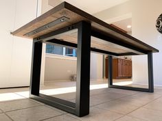 a wooden table with metal legs in an empty room