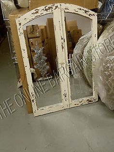 an old white double door mirror is sitting on the floor next to some cardboard boxes