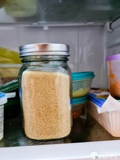 an open refrigerator door filled with food and containers on the shelf next to each other