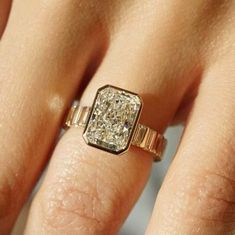 a woman's hand with a diamond ring on it