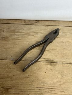 a pair of pliers sitting on top of a wooden floor