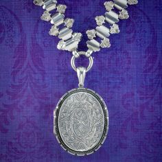 A magnificent antique Victorian collar from the late 19th Century bestowed with a large locket chased with elaborate patterning on both sides including a bouquet of forget me nots on the reverse, representing eternal love and remembrance.   The large collar articulates fluidly and has a wonderful, ornate design with further engraved artistry across the length. Both are fashioned in sterling silver and the locket is complete with rims and a window, ready to store two cherished family portraits so Ceremonial Medallion Jewelry With Historical Design, Victorian Oval Necklaces With Antique Finish, Victorian Oval Necklace With Antique Finish, Victorian Oval Jewelry With Historical Design, Antique Medallion Jewelry With Historical Design, Traditional Medallion Jewelry With Historical Design, Victorian Filigree Locket Necklace For Anniversary, Victorian Hallmarked Necklaces For Ceremonial Occasions, Victorian Hallmarked Necklaces For Ceremonial Events