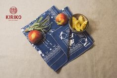 two bowls filled with fruit sitting on top of a blue napkin next to each other